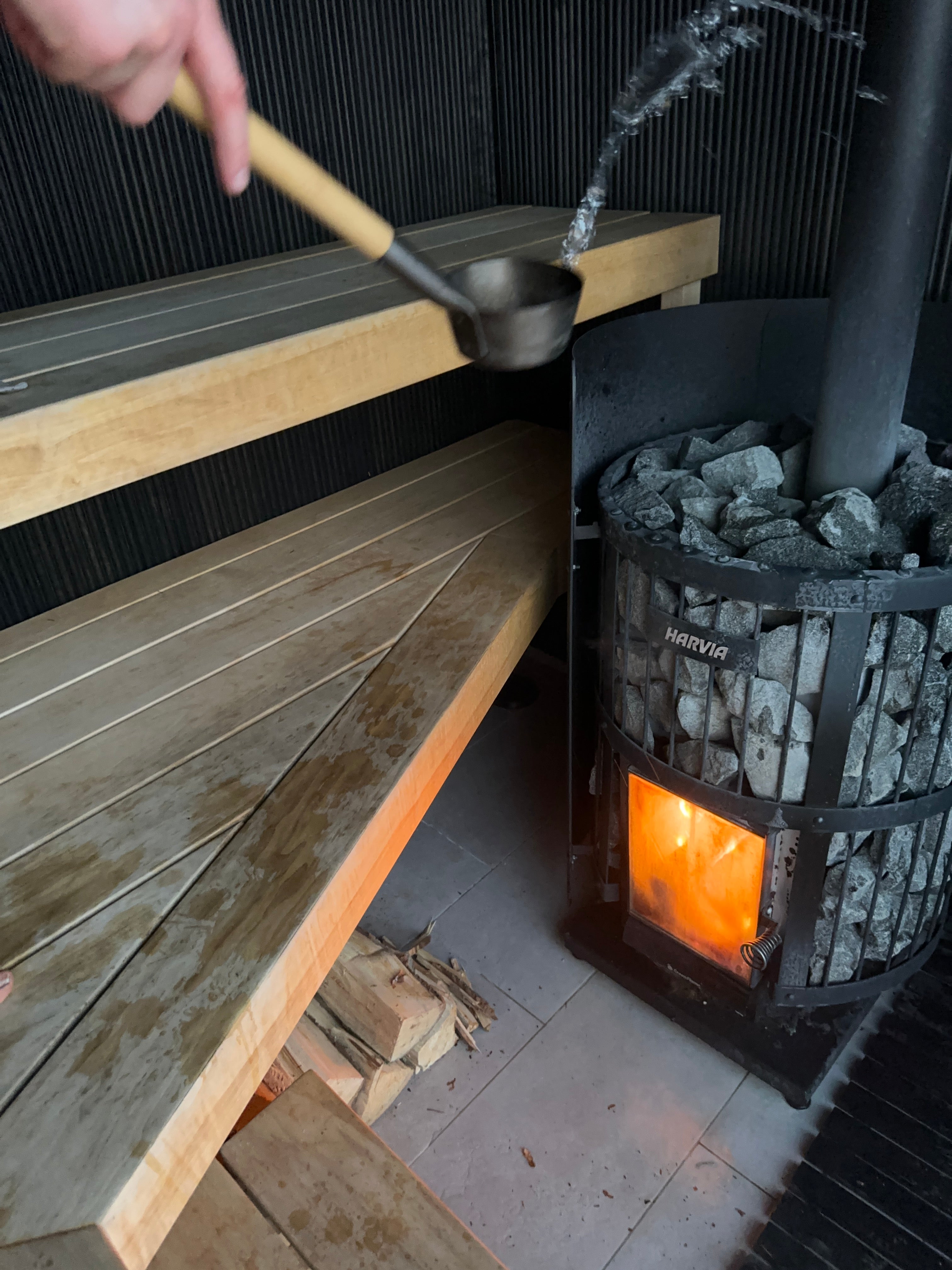 Water being poured on hot stones in a finnish sauna in stockholm